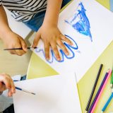 person tracing his hand on paper